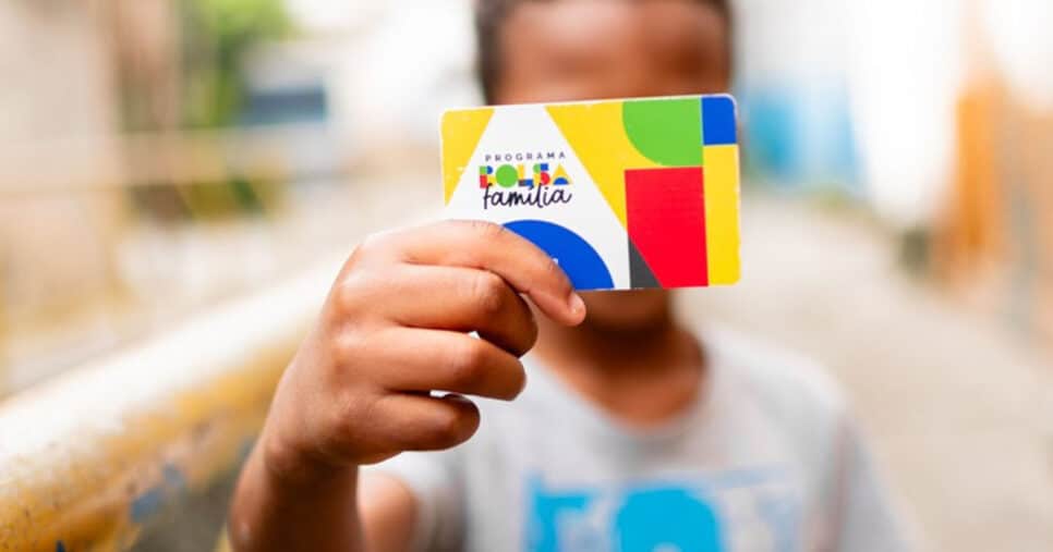 Criança segurando cartão do Bolsa Família (Foto: Reprodução) 